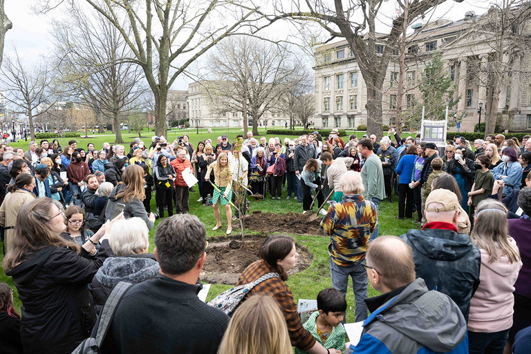 A large gathering surrounds the site of the Anne Frank Tree planting.