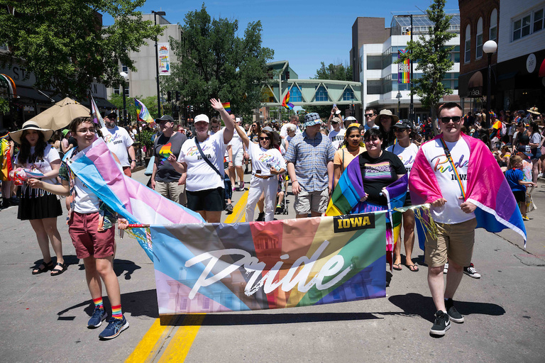 Parade leaders march down Linn Street during the 2022 Iowa City Pride Parade.