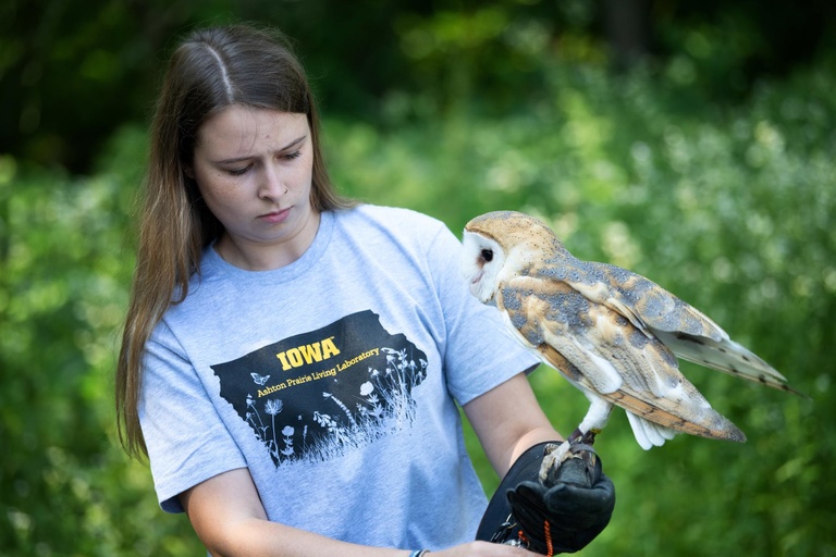A student attending the event carefully holds an owl at the Ashton Prairie Living Laboratory.