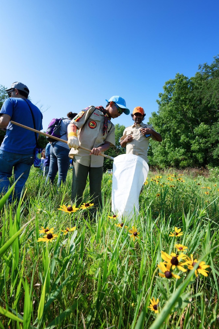 Attendees of the 2nd Annual BioBlitz take a look inside the net to observe findings.
