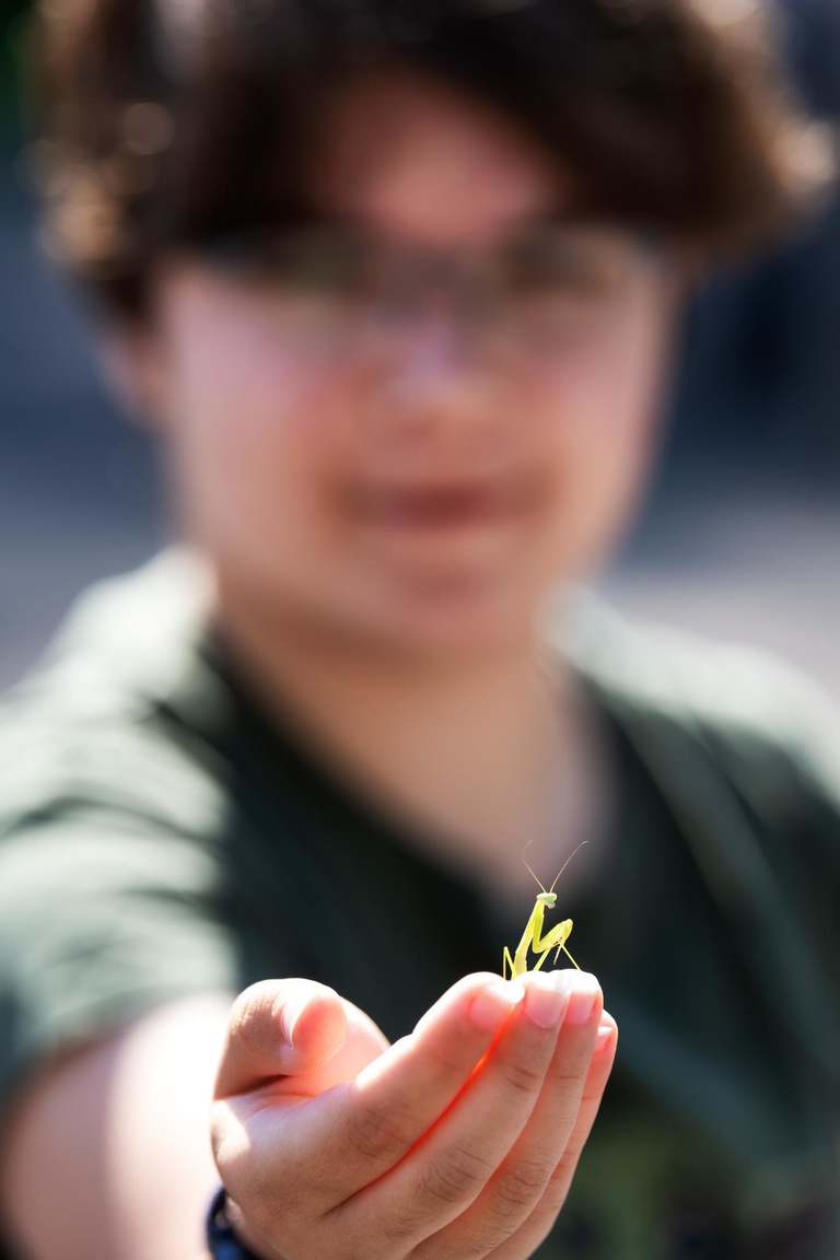 A student holds out a Praying Mantis at the Ashton Prairie Living Laboratory.