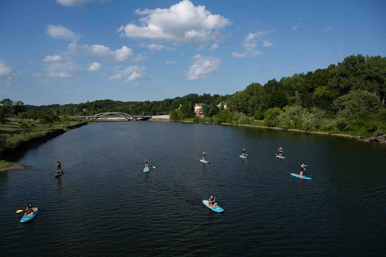 Students participate in an OnIowa! event, paddle boarding on the Iowa River.