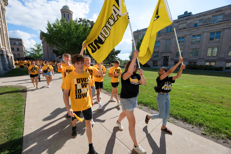 Students head from the Pentacrest to the President's Residence for the OnIowa! Block Party.