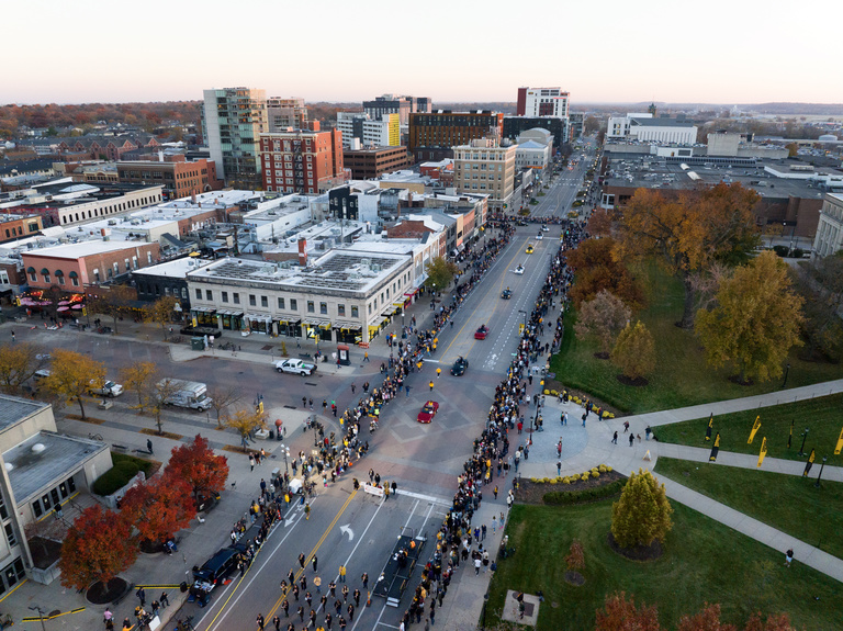 Distinguished alumni, grand marshals, and UI President Barbara Wilson make their way through the streets of Iowa City during the UI Homecoming Parade on Oct. 28.