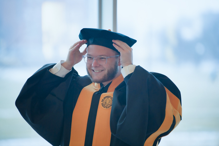 The Graduate College kicked off commencement weekend with doctoral degree candidates on Friday, Dec. 16. This graduate fixes his cap.
