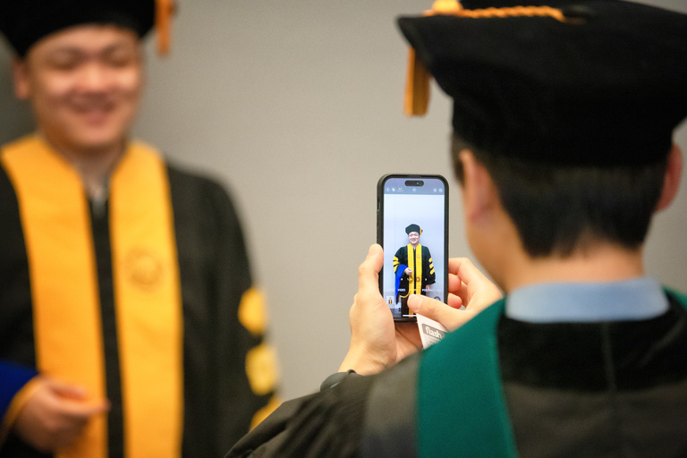 Graduate College graduates take photos before the ceremony on Friday, Dec. 16.