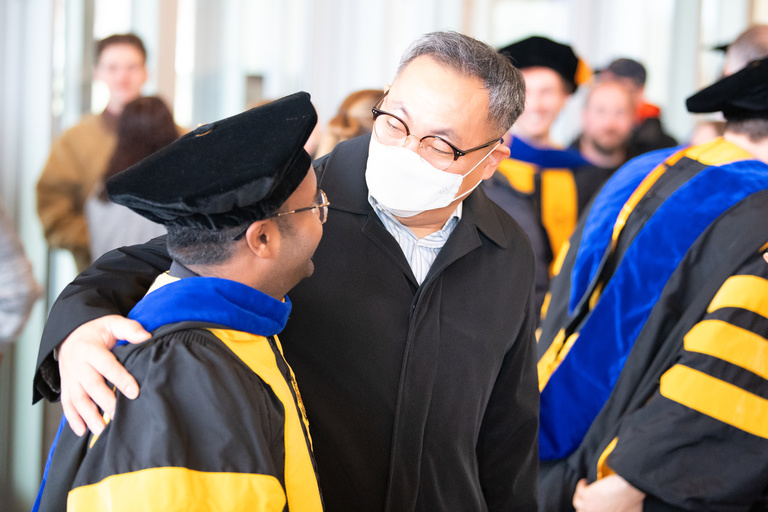 A father congratulates his son after the doctoral commencement ceremony on Friday, Dec. 16.