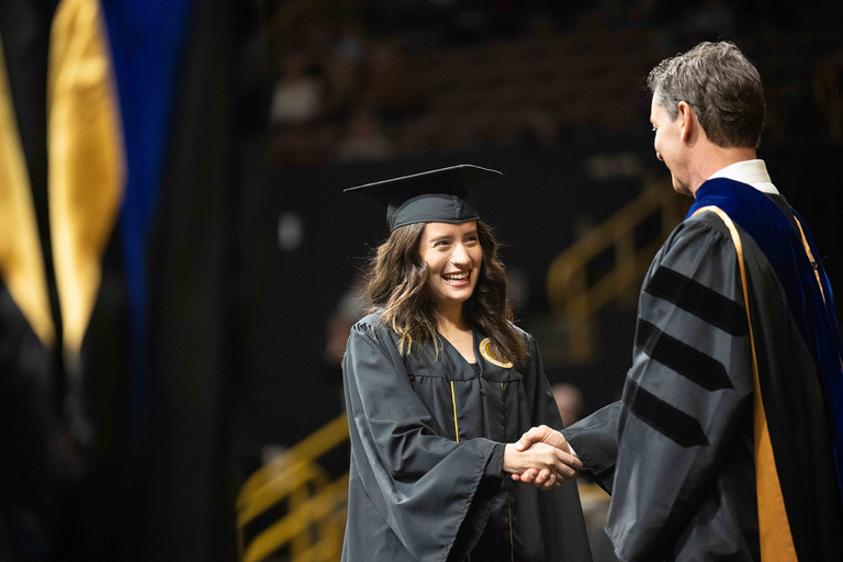 A graduate shakes the hand of Executive Vice President and Provost Kevin Kregel during the College of Liberal Arts and Sciences commencement ceremony Saturday, Dec. 17.