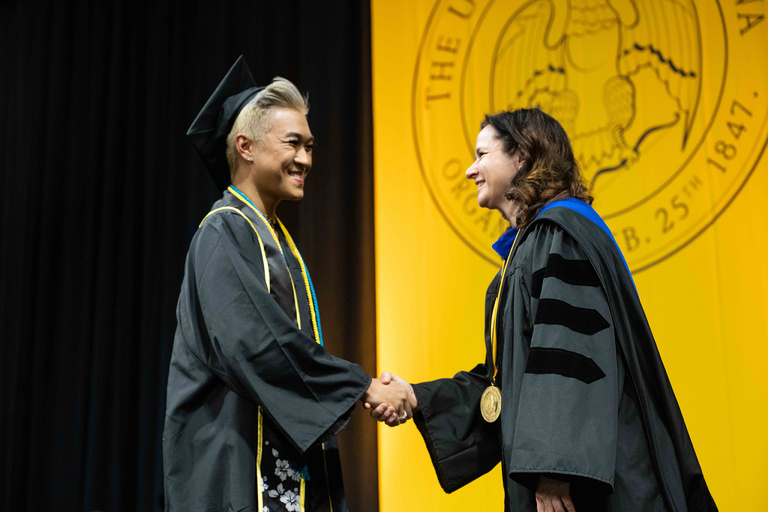 A CLAS graduate shakes the hand of dean Sara Sanders during the commencement ceremony Saturday, Dec. 17.