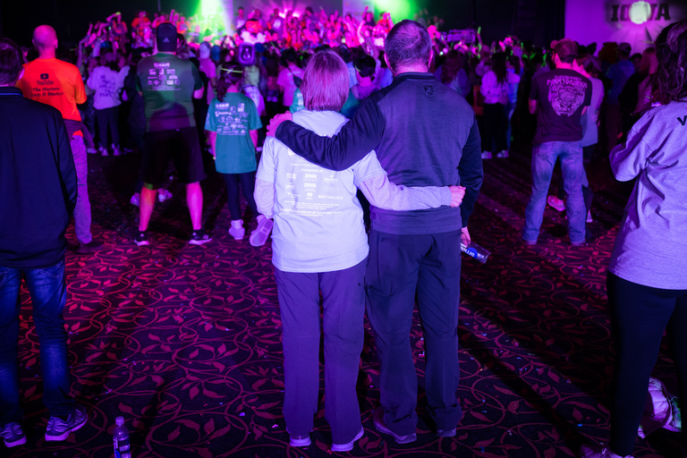 A couple looks on the dancing crowd during Dance Marathon 29.