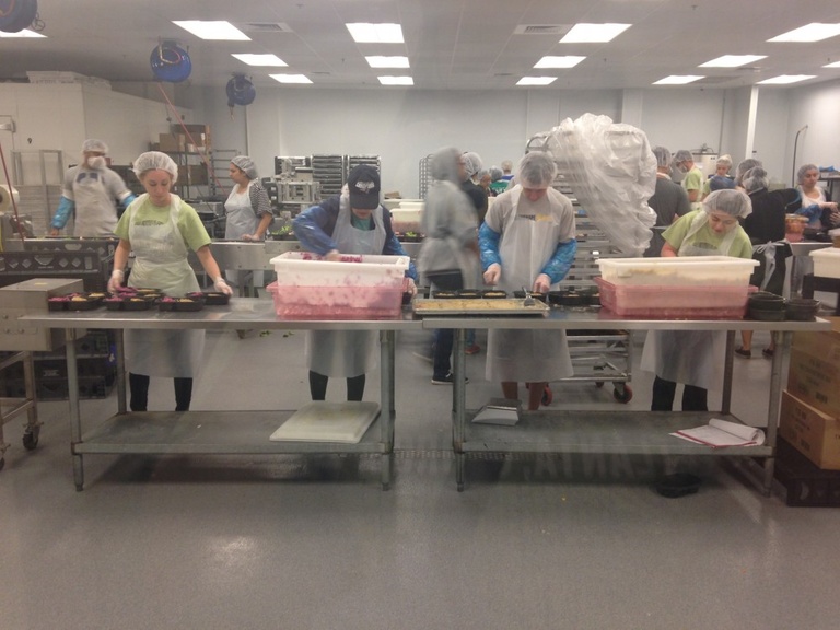 A group of students help package food.