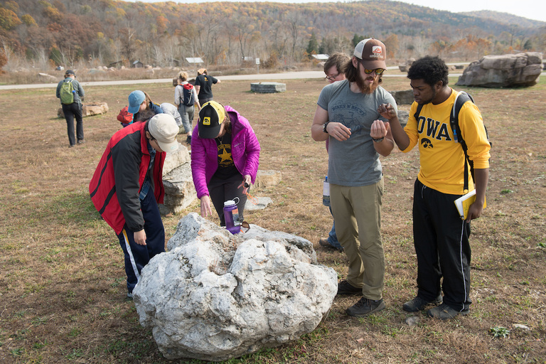 Faculty and students examine specimens found along the ground at the entrance to Johnson’s Shut-Ins State Park. 