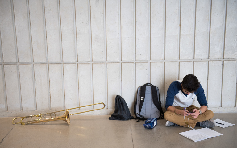 student with notebook and trombone