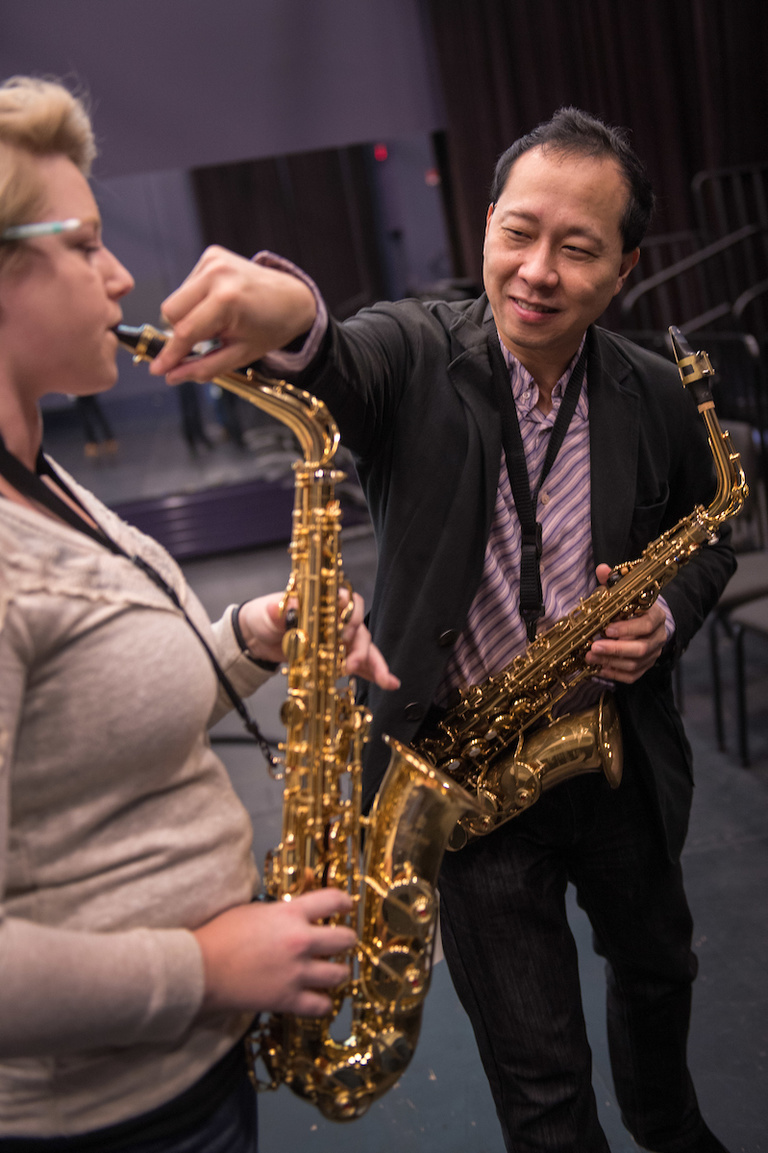 Kenneth Tse helps a student adjust a piece on a saxophone they were trying out. Instrument vendors occasionally come to campus to let students try out, or buy, new instruments.