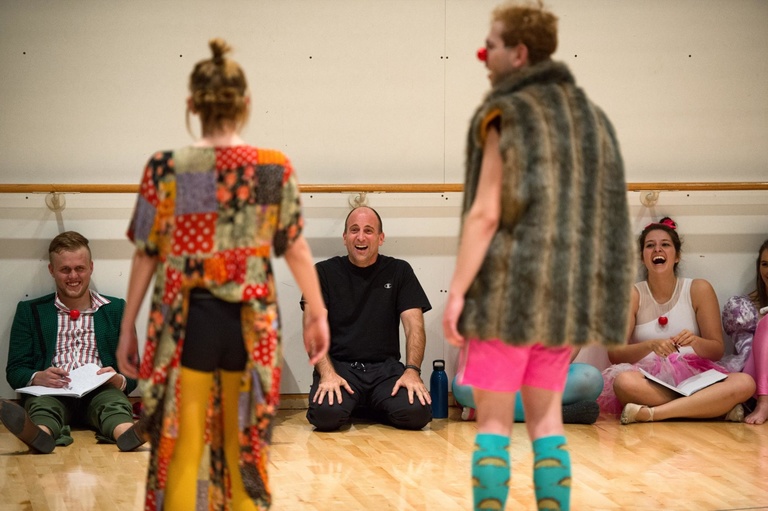 Professor Paul Kalina laughs at two students presenting a mimed clown skit.