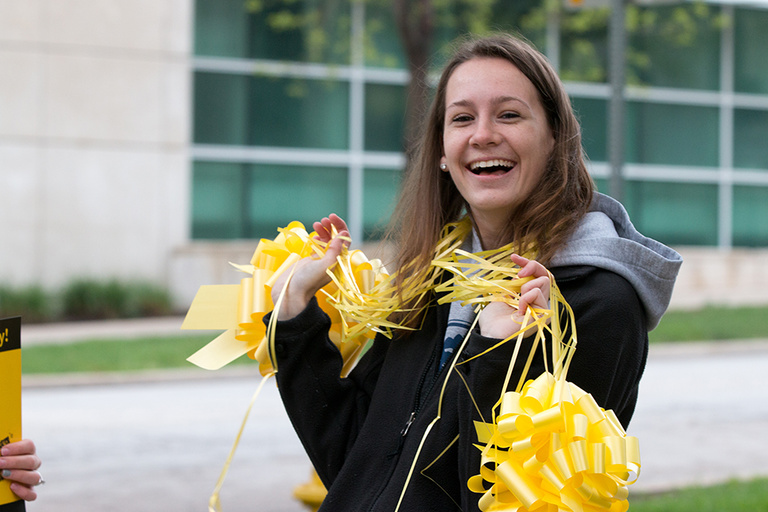 Student Philanthropy Group (SPG) member Taylor Palensky helped tag campus buildings with yellow bows.