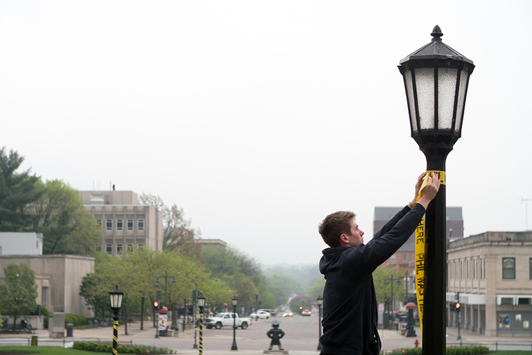 UI freshman and SPG member Ryan Brennan helped decorate the Pentacrest with Phil Was Here ribbons.