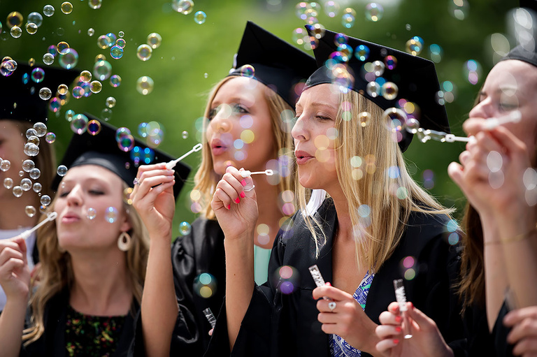 2015 graduates blow bubbles on the Pentacrest.