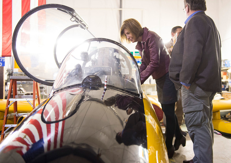 Iowa Sen. Rita Hart peers into the cockpit of an L-29 Delfin jet used by the UI Operator Performance Lab for research on flight decks, airborne sensor systems, Unmanned Aerial Vehicle (UAV) systems, and other areas.