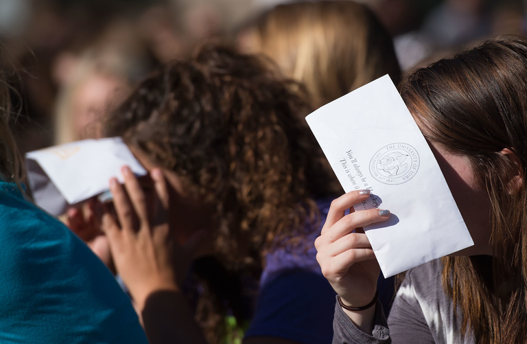 Convocation-goers shield their eyes from the sun.