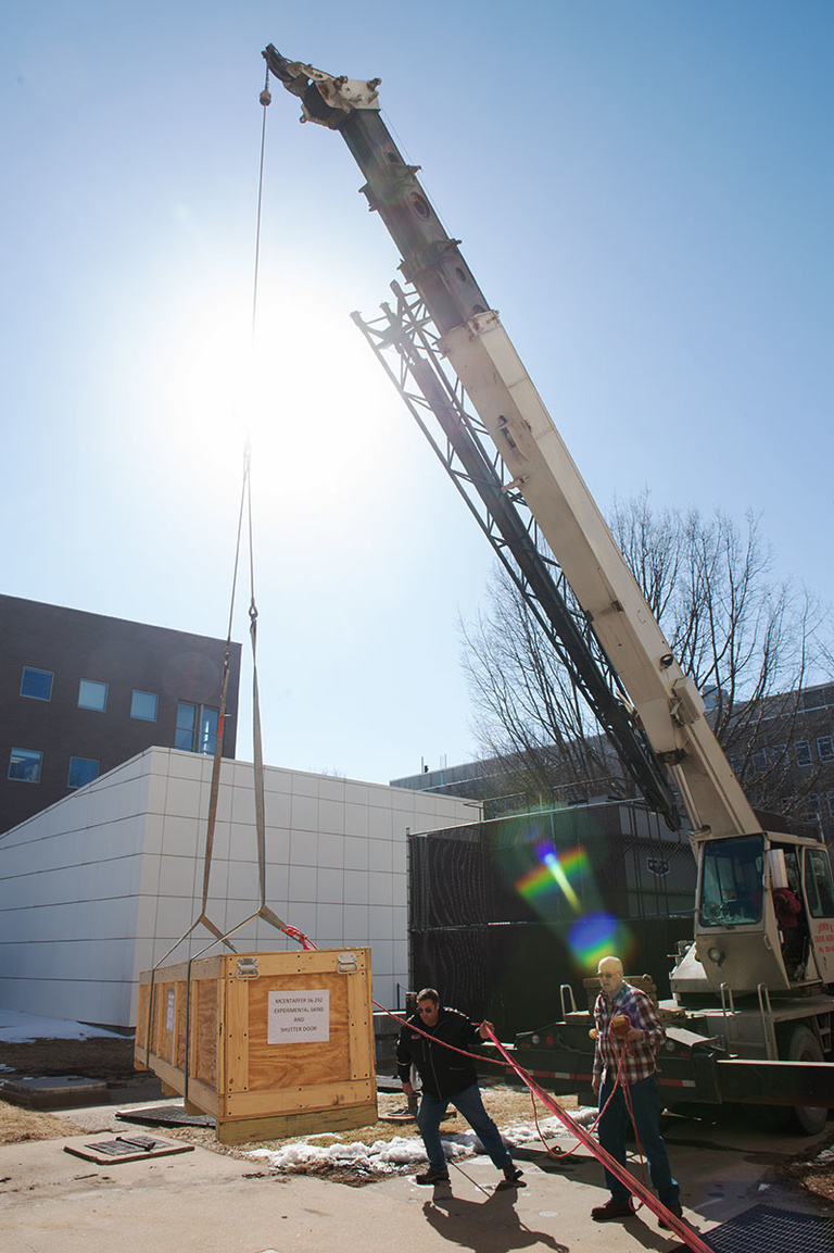Crane lifts a crate out of a basement facility.