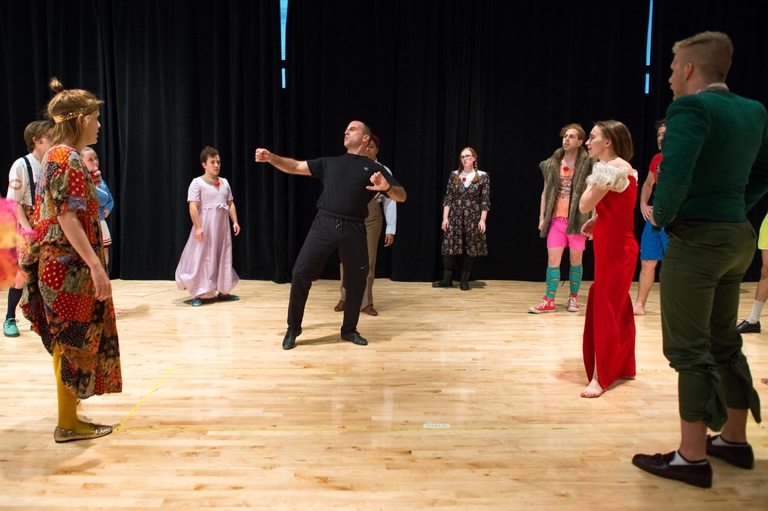 Professor Paul Kalina at the center of a circle of theatre students. 
