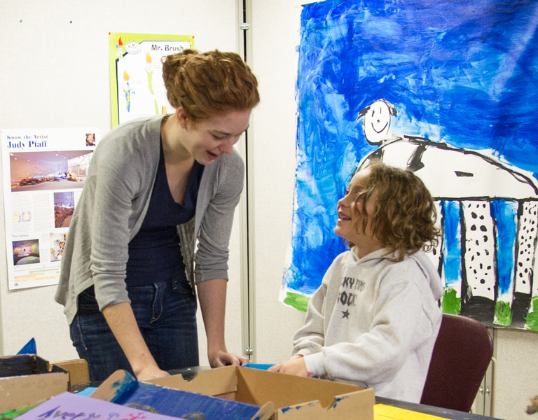 Art Education student teacher engages young artist.