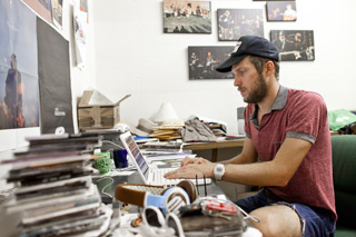 Sean Moeller sits before a computer in cluttered office