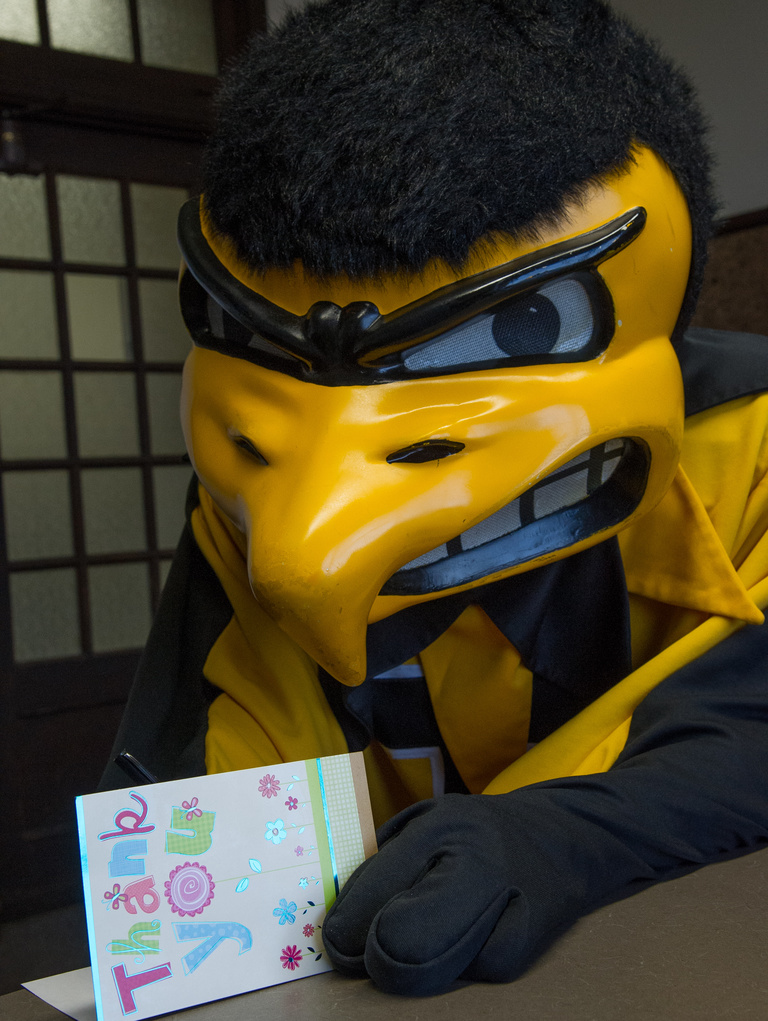 Herky signing a Thank You card.