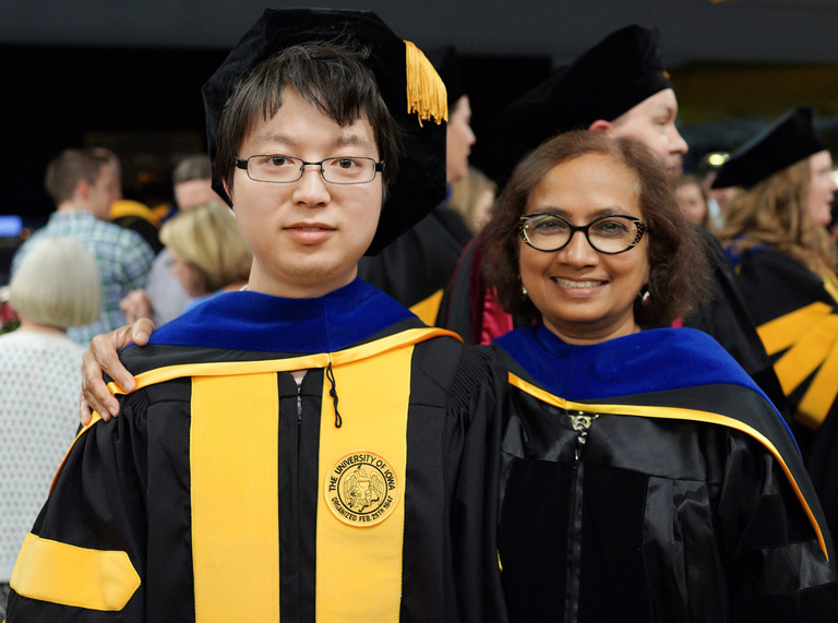man and woman posing at commencement ceremony