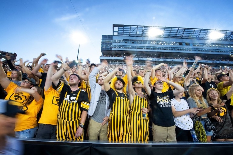 Students participate in the Iowa Wave at an Iowa football game inside Kinnick Stadium