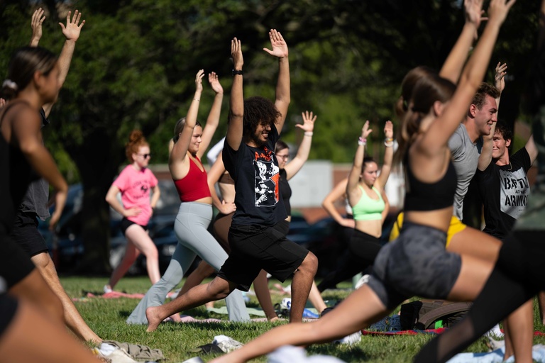 Students doing yoga in the park