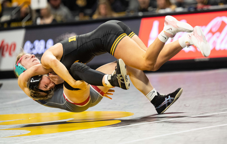an Iowa wrestler takes an opponent to the mat