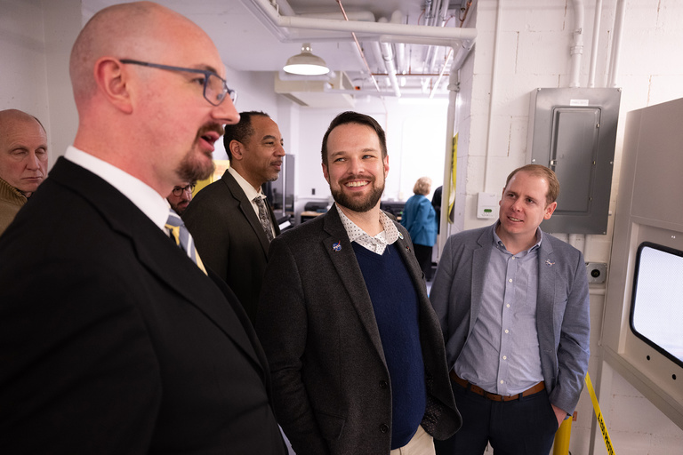 David Miles, associate professor in physics and astronomy and principal investigator for TRACERS, shows officials from NASA a lab in Van Allen Hall 