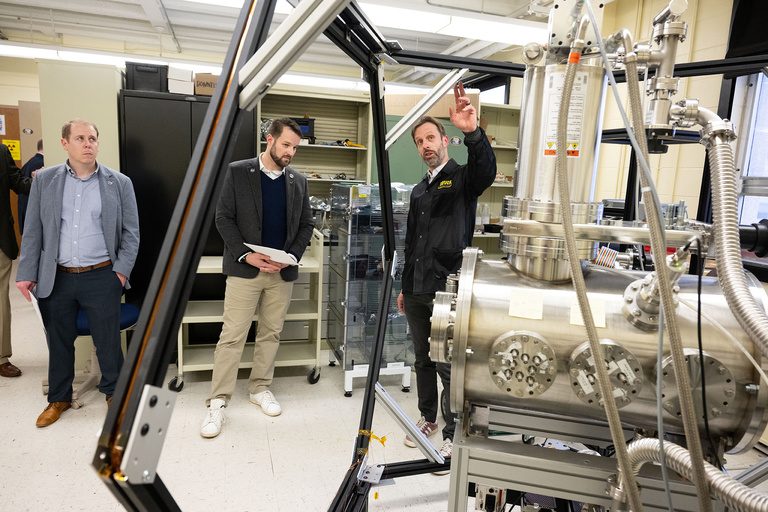 Jasper Halekas (right), professor in the Department of Physics and Astronomy, describes a calibration chamber in his lab in Van Allen Hall 