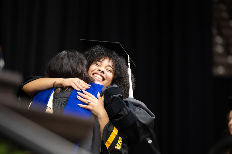 Graduates hugging at spring 2024 commencement 