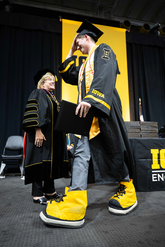 Graduate on stage at spring 2024 commencement
