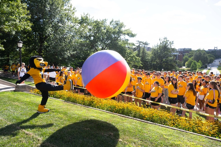Herky kicking a giant beach ball