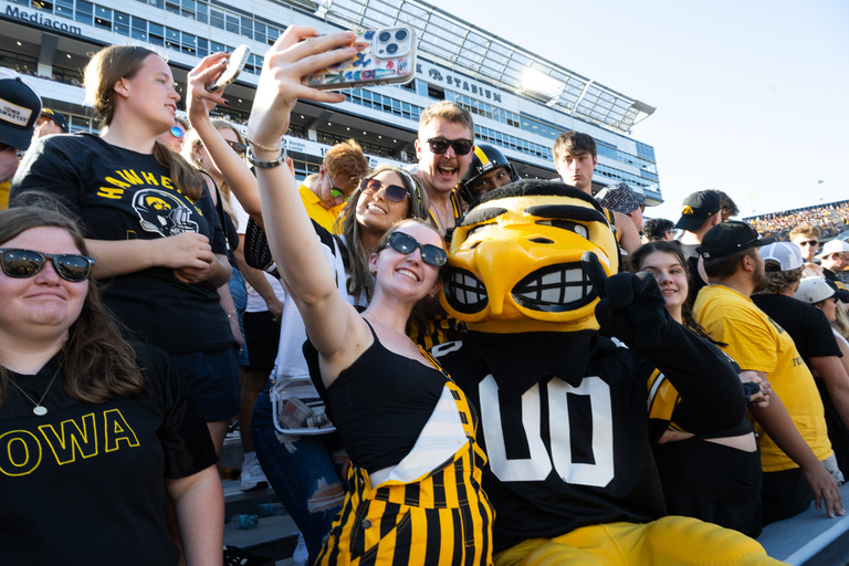 Herky the Hawk celebrates with students at the Iowa vs. Indiana football game