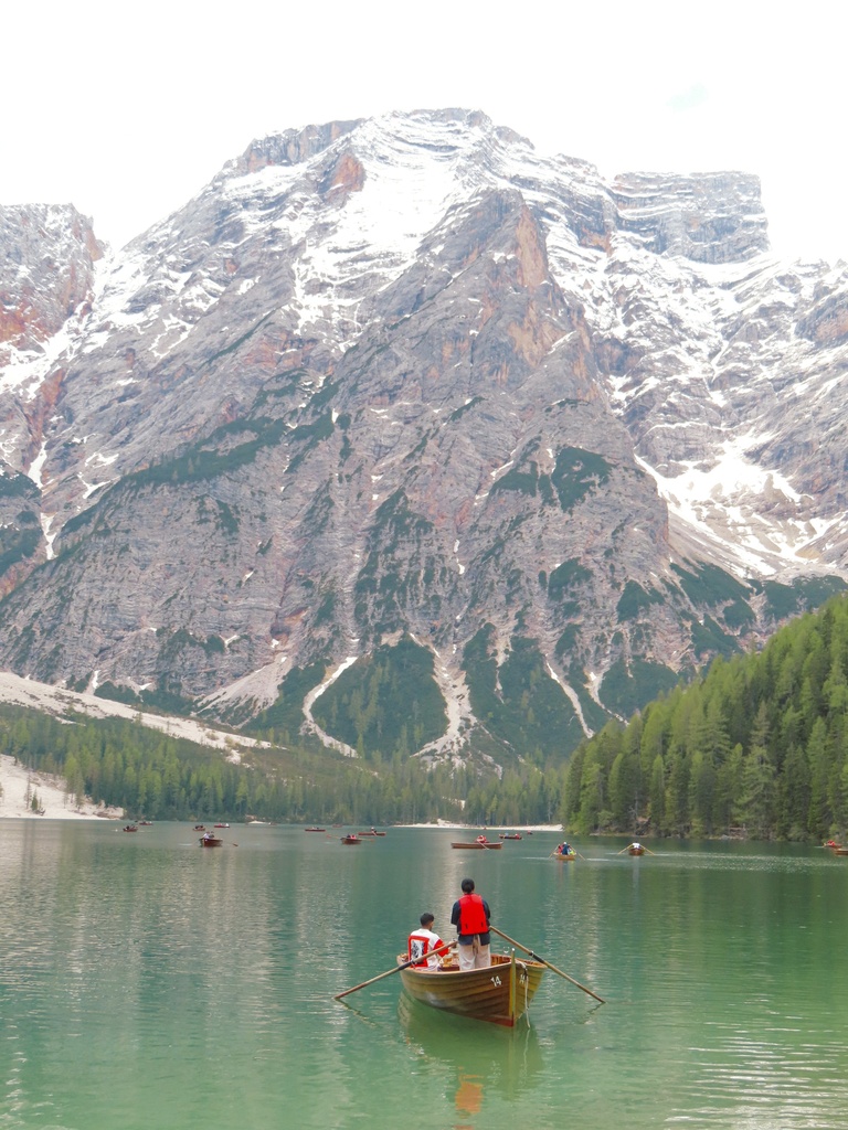 People in boats on a lake with a mountain in the background