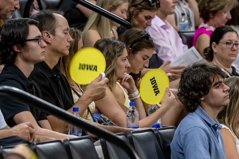 Friends and families fan themselves inside Carver-Hawkeye Arena