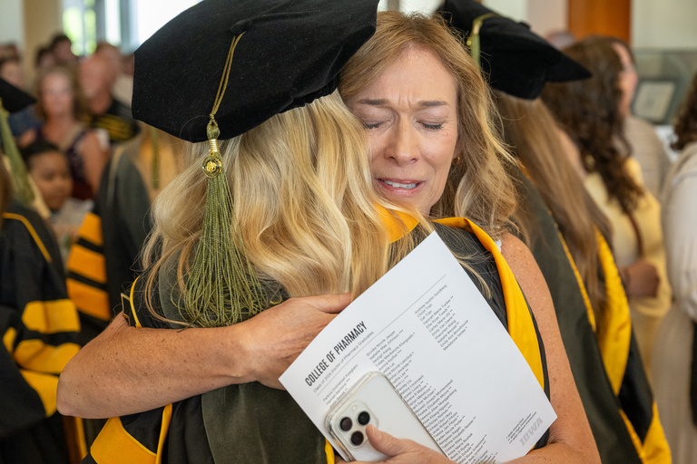 A parent hugs their graduate