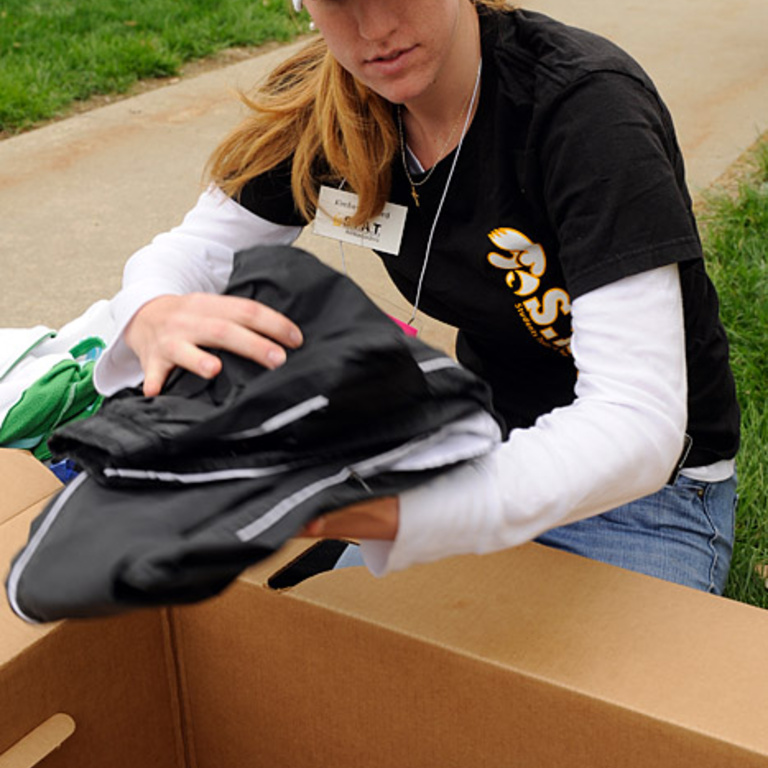 Kimberley Reed puts donated clothing into a box.