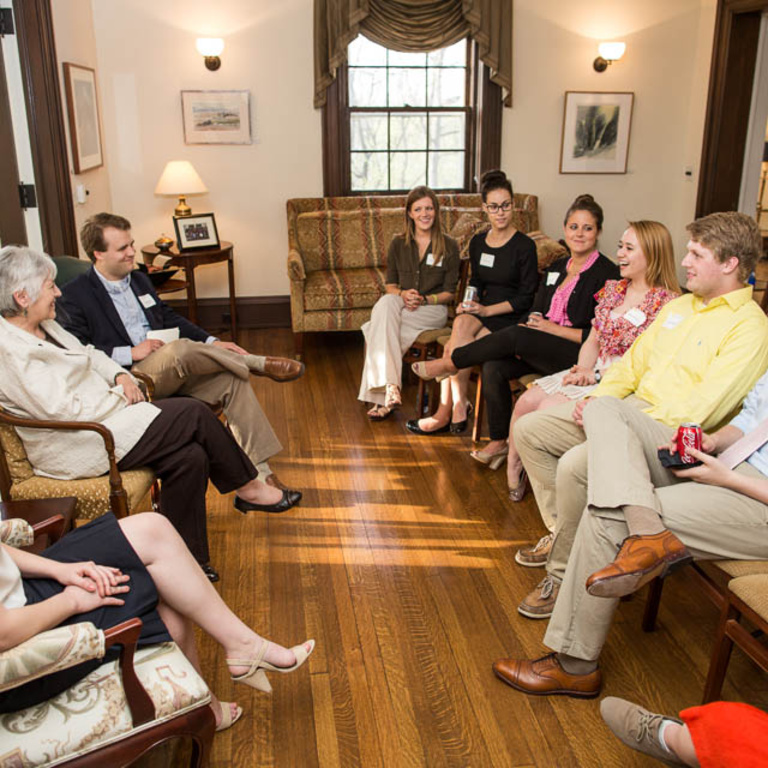 A group of people sits in a circle, talking.