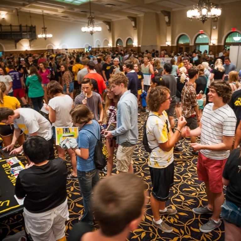 Dozens of people swarm tables in the Iowa Memorial Union main lounge.