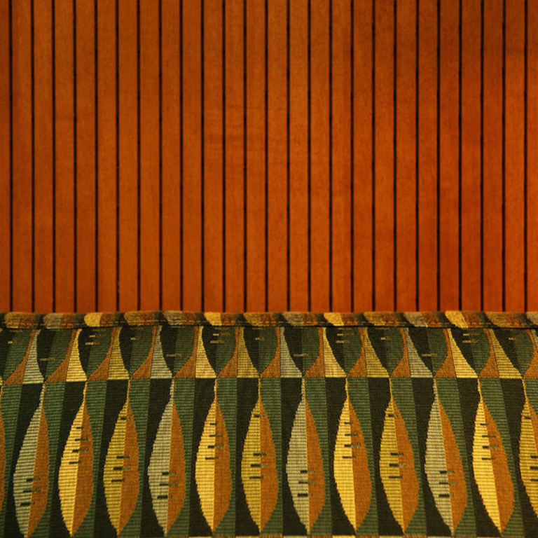 Detail of grooved wood paneling and abstract leaf printed upholstery. 