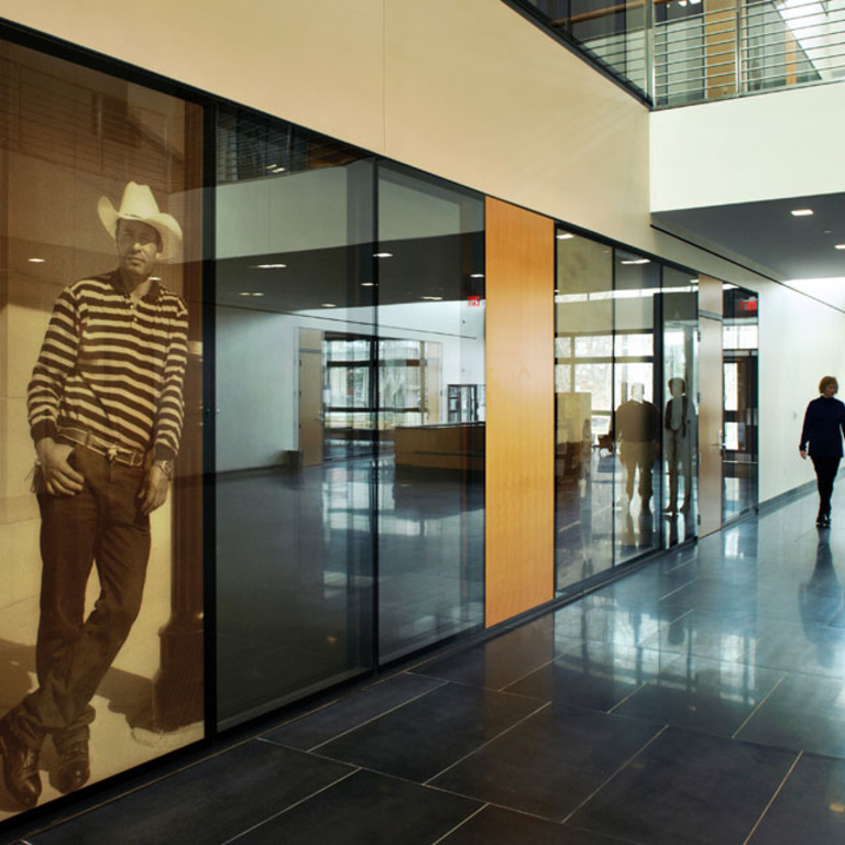 Two people walk toward a life-size photographic wall panel.