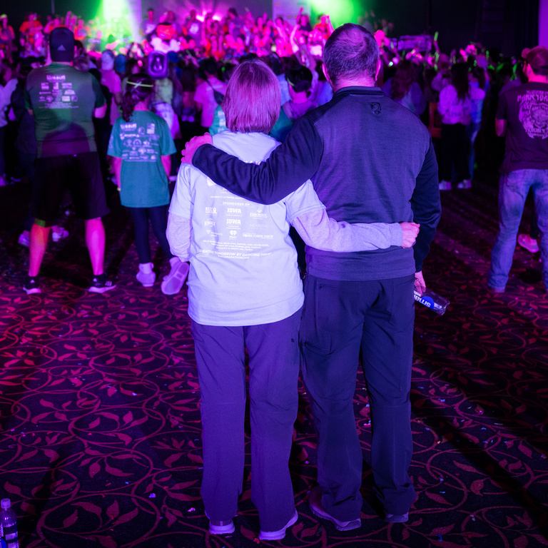 A couple looks on the dancing crowd during Dance Marathon 29.