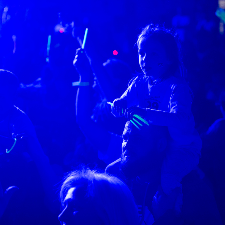 A child sits on her dad's shoulders during Dance Marathon 29.