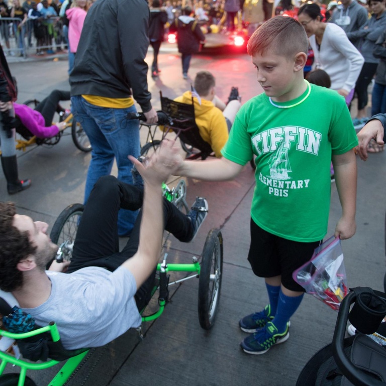 tiffin elementary student high fives recumbent cyclist